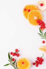 Flat lay composition. Citrus fruits and red currants with green leaves on a white background. Mandarin. Ingredients for perfume. Mock up.