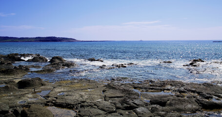 Fototapeta na wymiar Sea over the rock beach in sunny day