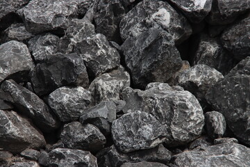 Black stones on a pile for usage for water protection in IJmuiden