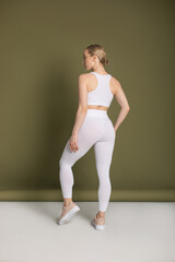 Fototapeta na wymiar Young woman in a white sports top and leggings. Mock-up.