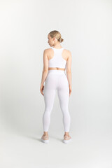 Naklejka premium Young woman in a white sports top and leggings. Mock-up.