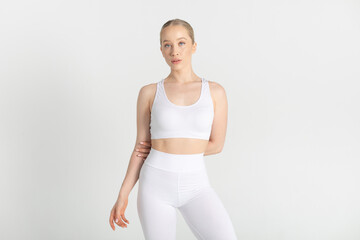 Young woman in a white sports top and leggings. Mock-up.