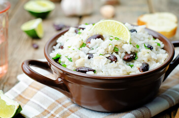 Coconut lime rice with red beans and cilantro in a bowl on a wood background