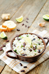 Coconut lime rice with red beans and cilantro in a bowl on a wood background