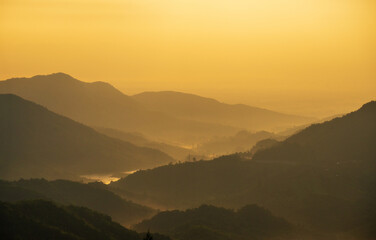 Morning sky and mountains, golden orange tones.