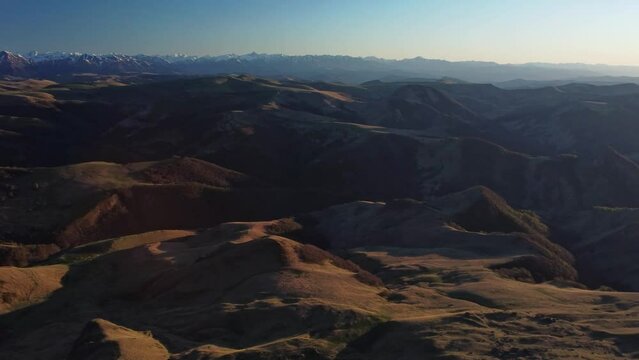 a bird's-eye view of the Caucasus mountains and Elbrus at sunset. Elbrus is the highest peak in Europe