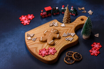 Elements of Christmas decorations, sweets and gingerbread on a wooden cutting board