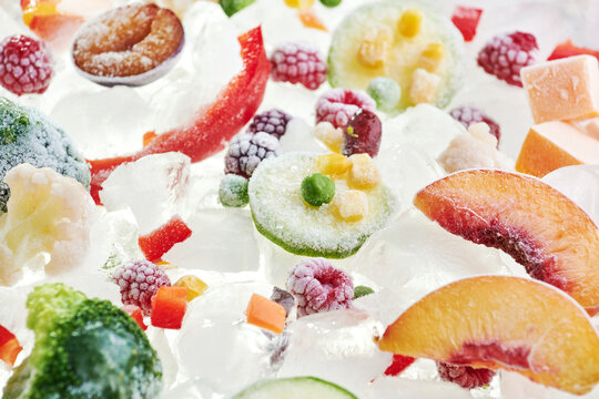 Background of frozen sliced vegetables on ice. Stocks of food consept. View above
