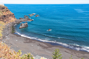 Panoramic aerial view on the dark fine lava sand beach Playa El Bollulo near near Puerto de la Cruz, Northern Tenerife, Canary Islands, Spain, Europe. Beautiful coastline with no people. Hiking trail