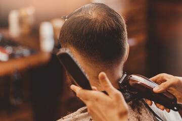 Barbershop vintage color. Man in barber chair, hairdresser master working with clipper and comb