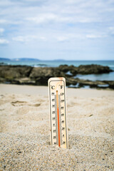 Thermometer on the beach marking high temperatures. Climate change. Global warming. Ecological...