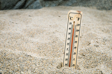Thermometer on the beach marking high temperatures. Climate change. Global warming. Ecological...