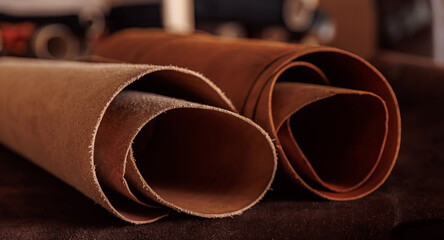 Closeup different rolls natural leather brown and beige color dark background