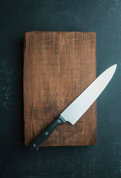 Empty kitchen background with old cutting board, knife and empty baskets for your product. food background.Top view.