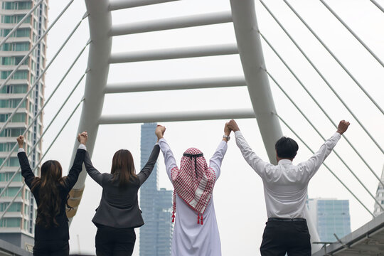 happy business team making high hands in sunset sky background for business teamwork concept