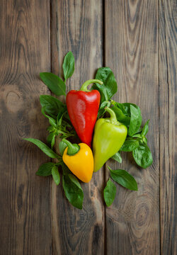 Sweet bell pepper with spices and aromatic herbs on a wooden background. Spices and vegetables. Healthy food. top view.