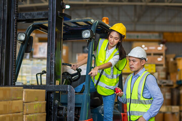 Worker at forklift driver working in industry factory logistic ship. Woman forklift driver in warehouse area.
