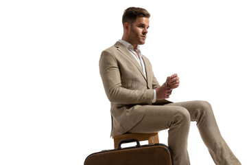 side view of elegant businessman looking to side and adjusting sleeve