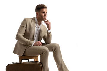 side view of handsome businessman holding elbow on knee