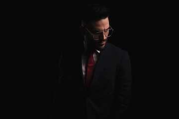 Obraz premium sexy young businessman in elegant suit with red tie looking down side