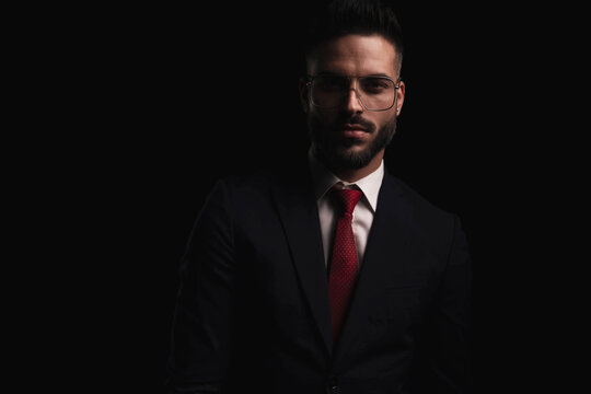 portrait of attractive man wearing elegant black suit with red tie