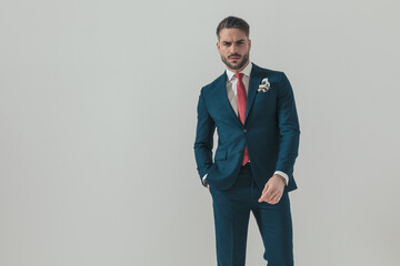 cool bearded guy wearing elegant suit and holding hand in pocket