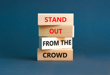 Stand out from the crowd symbol. Concept words Stand out from the crowd on wooden blocks on beautiful grey table grey background. Business, stand out from the crowd concept