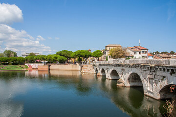 View of the oldest bridge, over 2000 years old, San Giuliano Mare at the other side above the port chanel in Rimini, Italy