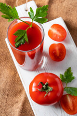 Dietary tomato juice on linen background. Healthy drink made from farm vegetables.
