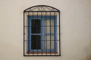 Old blue house window exterior. White wall