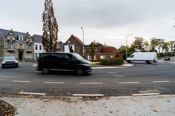 Roundabout with 3 cars driving in slow shuttertime to show movement, picture taken in city Izegem. ...
