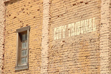 Old Far West city tribunal brick wall with window. Western scene