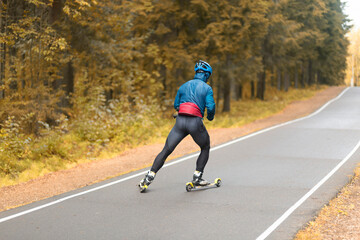 Cross country skilling.A man on roller skis rides in the autumn park.