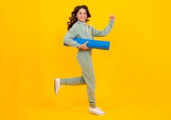 Fototapeta na wymiar Teenage girl dressed in sports uniform, posing in the studio. Child in a posh stylish sports suit in a hoodie with a hood. Advertising sportswear and yoga wear. Healthy kids lifestyle, sport.