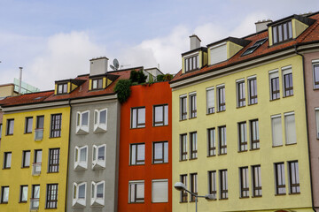 The exterior facade of a row of colorful modern townhouses in blue,red and gray