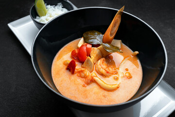 Thai soup with seafood and rice, on dark concrete