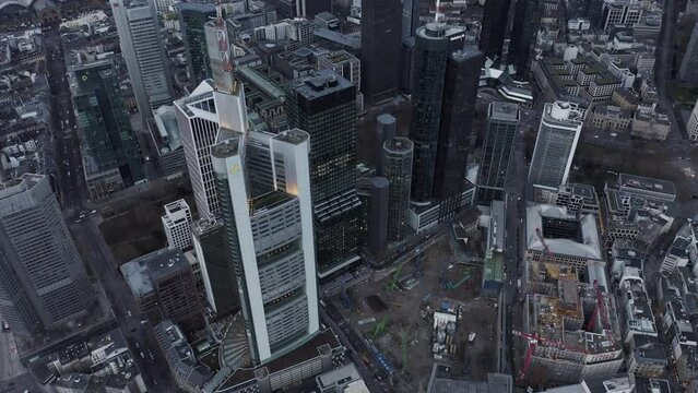 Fly above city. High angle view of construction site next by group of modern tall skyscrapers in business borough. Frankfurt am Main, Germany
