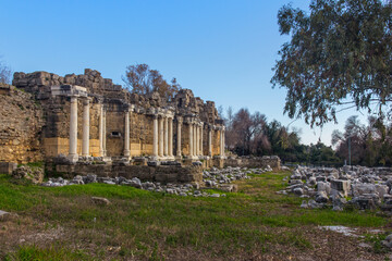 Fototapeta premium View of the ruins of the monumental ancient Roman fountain Nymphaeum with snow-white marble columns in the historic part of Antique Side, near Antalya, Turkey