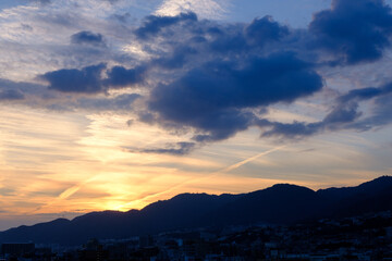 夕暮れ六甲山に陽が沈んだあと、まだオレンジ色の光が残る。神戸市内から六甲の稜線を撮影