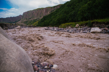 Muddy river water. Spring flood. Dirty muddy water with a whirlpool and white foam close-up.A...