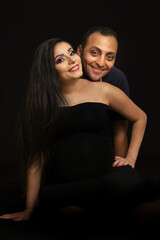 Portrait of a young couple waiting for a baby. Taken in a photo Studio on a black background. High quality photo