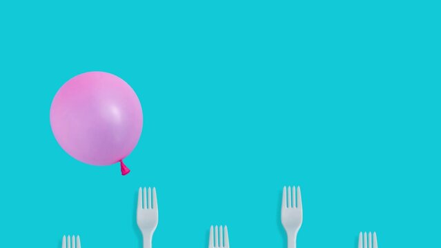 Pink balloon flying over kitchen forks on pastel blue background 4k.