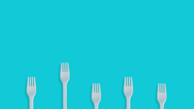 Creative business concept with pink balloon flying over kitchen forks on pastel blue background 4k.