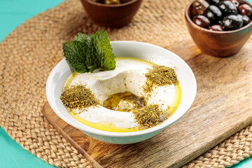 Lebneh Zaatar with olive served in a dish isolated on wooden table side view of middle eastern food