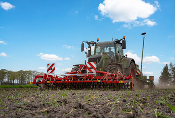 Traktor mit landwirtschaftlichen Geräten beim Maislegen.