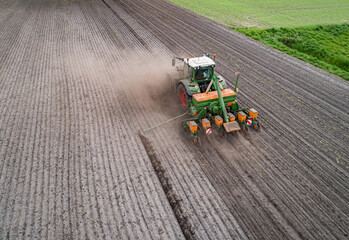 Luftaufnahme - Staubige Angelegenheit, Maissaat mit Traktor und Maschinen auf einen trockenen Acker. © Countrypixel