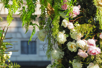 Arch of blooming peonies and fern leaves, symbols of love and energy