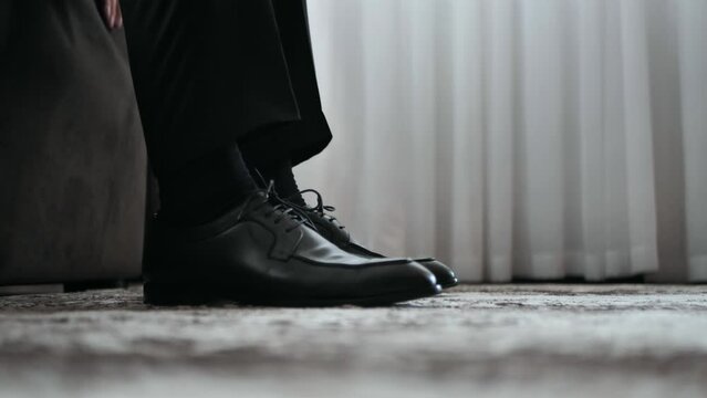 Businessman, groom, young business man puts on shoes and leaves. close-up.