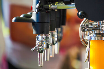 Taps for draft beer in a modern bar. Detail of beer machine, beer dispenser, close-up, selective...
