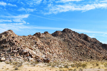 rock desert mountain terrain landscape blue sky hiking trail adventure area clouds weather overcast